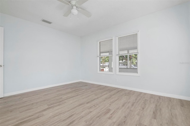 empty room featuring light wood-style floors, baseboards, visible vents, and a ceiling fan