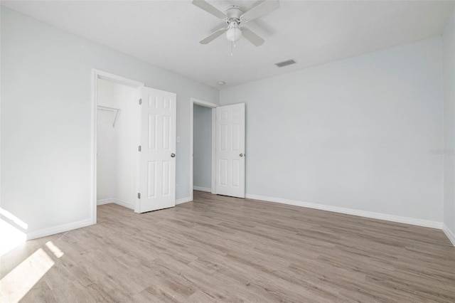 unfurnished bedroom featuring visible vents, baseboards, and wood finished floors