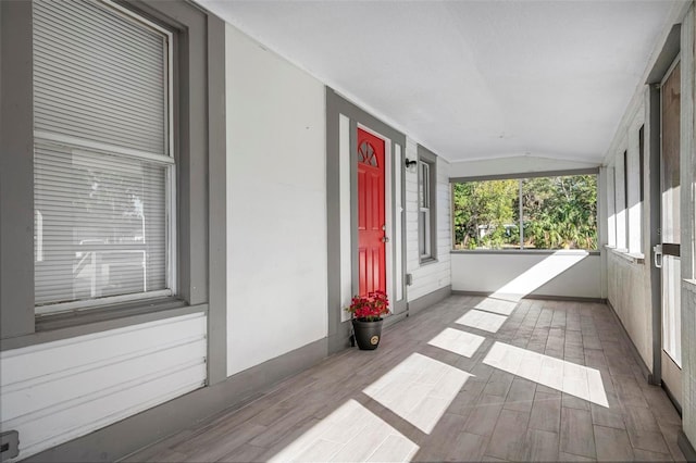 unfurnished sunroom featuring vaulted ceiling