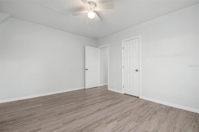 empty room with a ceiling fan, baseboards, and wood finished floors