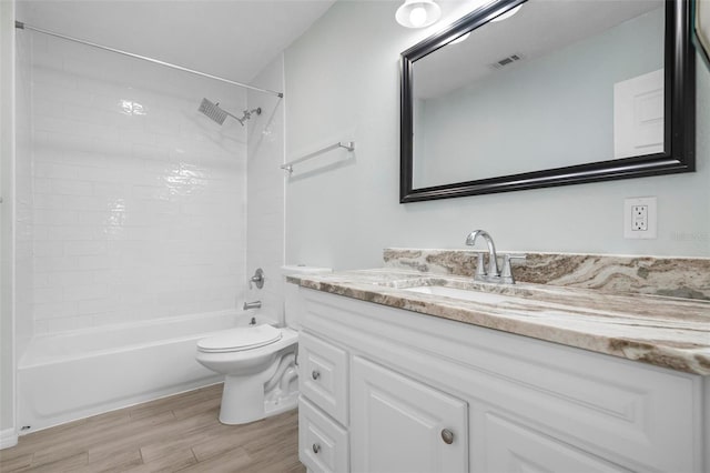 full bathroom with visible vents, toilet, vanity, wood finished floors, and  shower combination