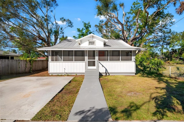 view of front of house featuring a front lawn and a sunroom