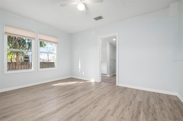 empty room featuring baseboards, visible vents, ceiling fan, and light wood finished floors