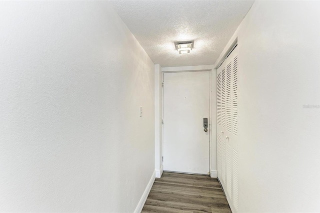 hallway featuring dark hardwood / wood-style floors and a textured ceiling