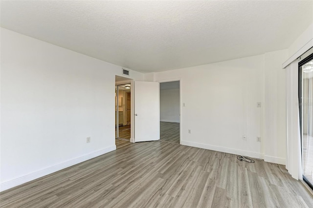 unfurnished bedroom with a textured ceiling and light wood-type flooring