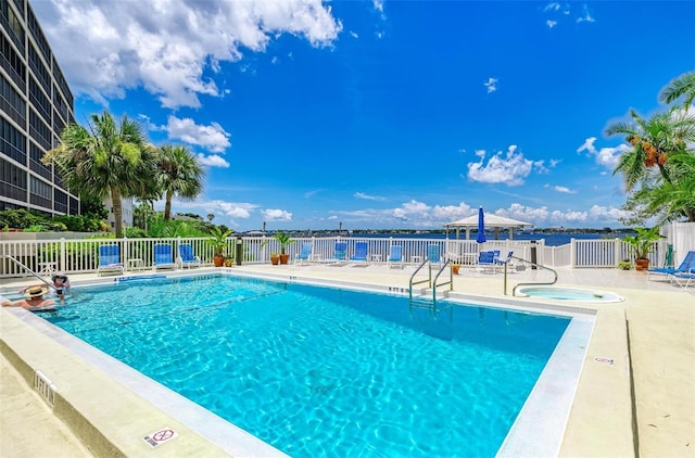 view of pool with a patio area, a water view, and a community hot tub