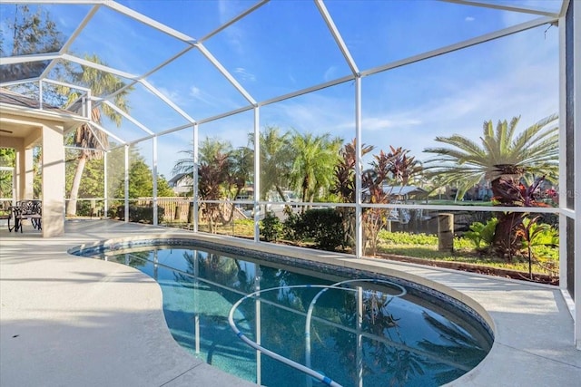 view of pool with a patio area and glass enclosure