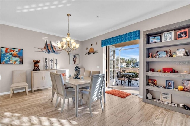 dining room with an inviting chandelier, light hardwood / wood-style floors, and crown molding