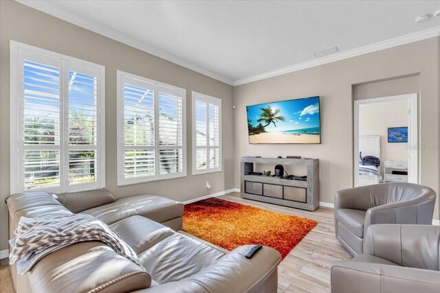 living room with ornamental molding, light hardwood / wood-style floors, and plenty of natural light