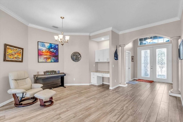 entryway with french doors, a chandelier, light hardwood / wood-style floors, and ornamental molding