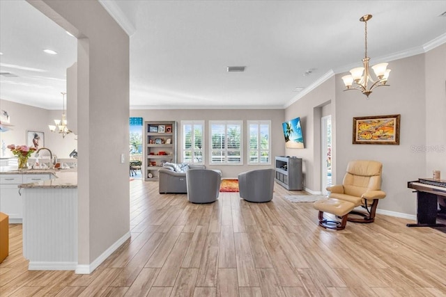 living room featuring light hardwood / wood-style floors, crown molding, and a chandelier