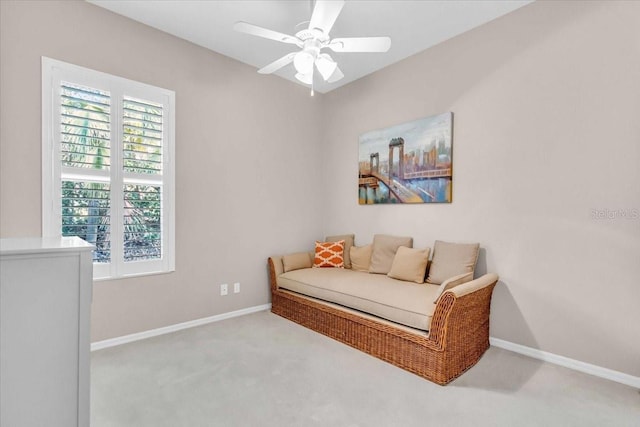 living area featuring light carpet and ceiling fan