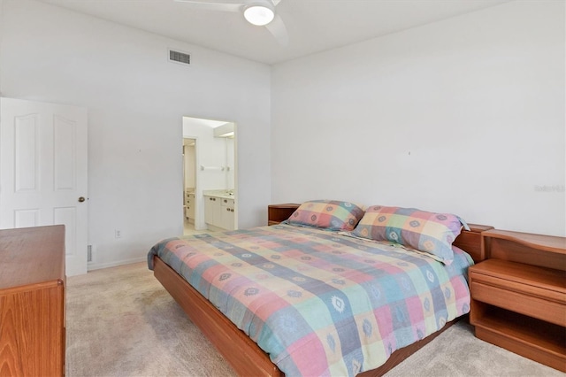 carpeted bedroom with visible vents, ensuite bathroom, and a ceiling fan