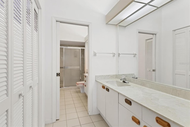 bathroom featuring walk in shower, vanity, toilet, and tile patterned flooring