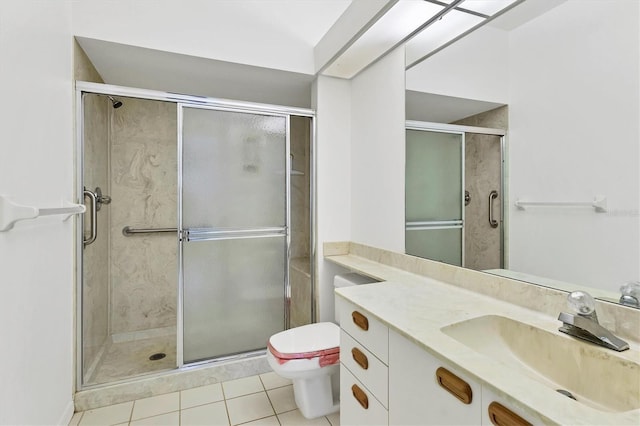 bathroom with tile patterned flooring, vanity, a shower with shower door, and toilet