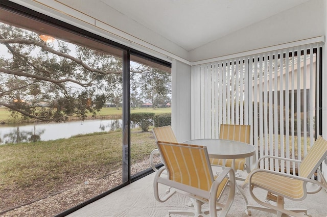 sunroom / solarium featuring a water view and vaulted ceiling