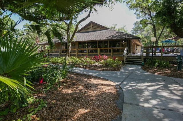 exterior space with roof with shingles and a wooden deck