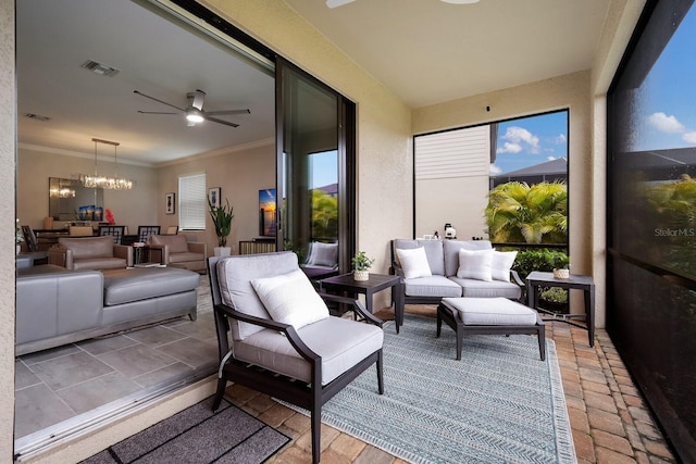 sunroom with ceiling fan with notable chandelier