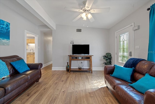 living room featuring light hardwood / wood-style flooring, ceiling fan, and sink