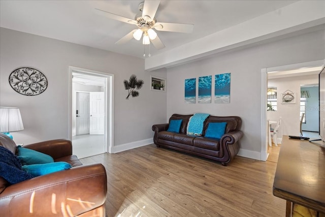 living room with light hardwood / wood-style flooring and ceiling fan