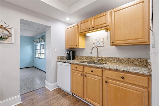 kitchen featuring dishwasher, light brown cabinets, sink, light hardwood / wood-style flooring, and light stone counters