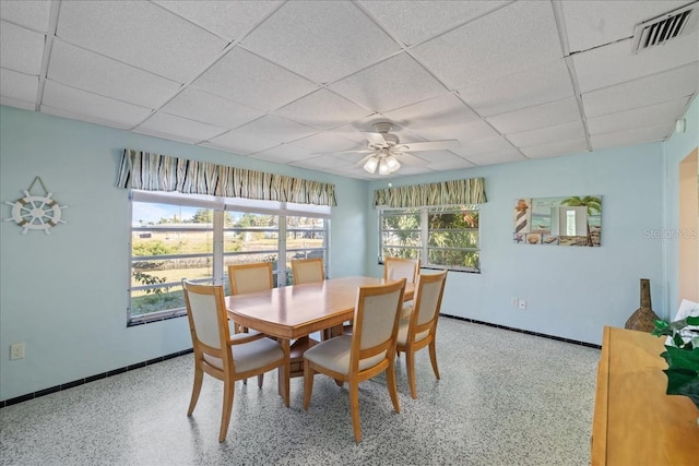 dining space with a paneled ceiling and ceiling fan