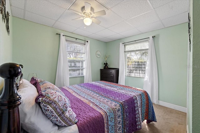 bedroom with carpet, a drop ceiling, and ceiling fan