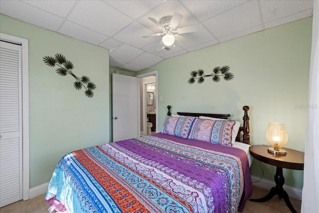 bedroom with a paneled ceiling, ceiling fan, and a closet