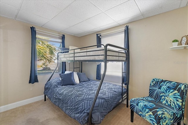 carpeted bedroom with a paneled ceiling