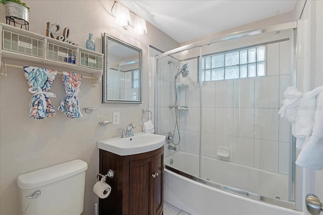 full bathroom with shower / bath combination with glass door, tile patterned floors, vanity, and toilet