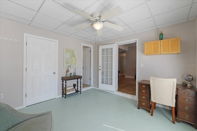 office with french doors, a paneled ceiling, and ceiling fan