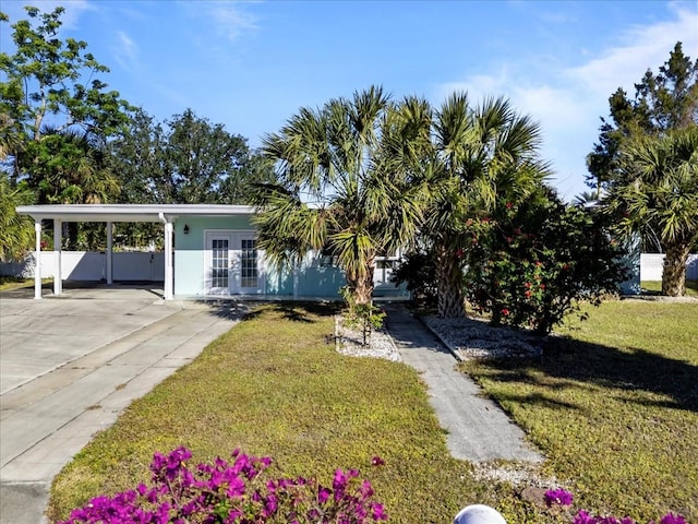 view of front facade featuring french doors, a front yard, and a carport