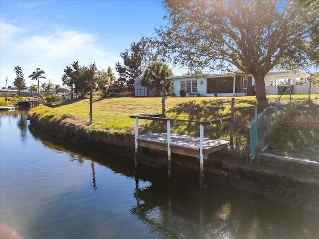 dock area with a yard and a water view