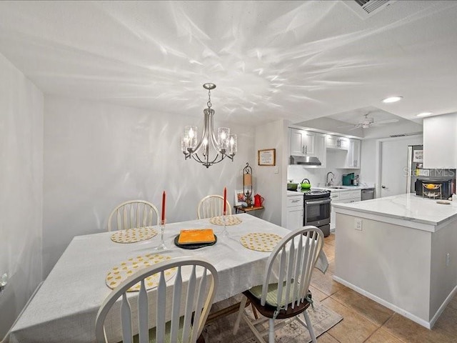 tiled dining area with ceiling fan with notable chandelier and sink