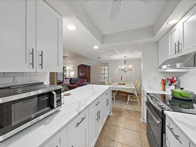 kitchen with appliances with stainless steel finishes, backsplash, and white cabinetry