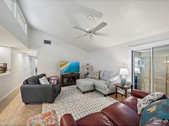 living room featuring ceiling fan, light tile patterned floors, a textured ceiling, and high vaulted ceiling