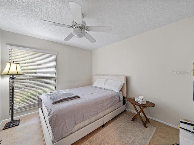 bedroom with ceiling fan, a textured ceiling, and multiple windows