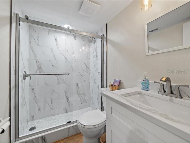 bathroom featuring tile patterned floors, vanity, toilet, and a shower with door