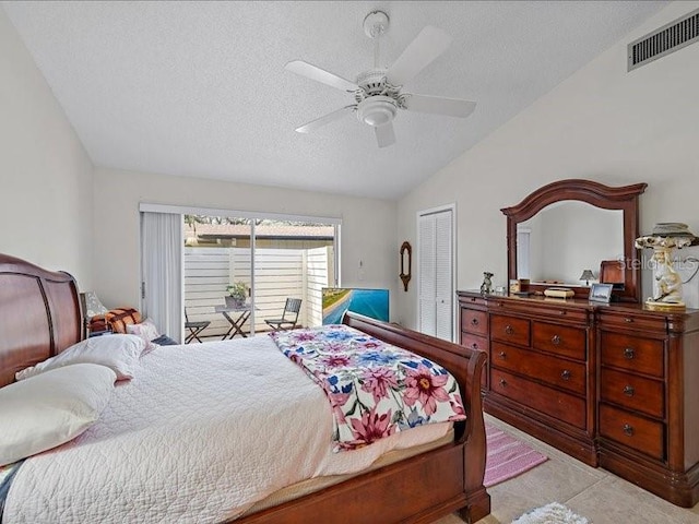 bedroom with a textured ceiling, a closet, ceiling fan, and lofted ceiling