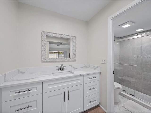 bathroom featuring walk in shower, vanity, and toilet