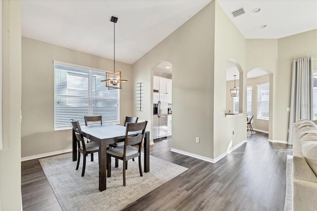 dining room featuring dark hardwood / wood-style flooring, a wealth of natural light, and a chandelier