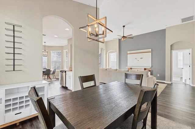 dining area featuring ceiling fan with notable chandelier and dark hardwood / wood-style flooring