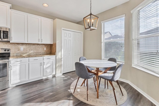 dining area with a notable chandelier and dark hardwood / wood-style floors