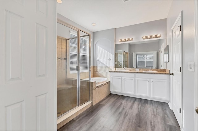 bathroom featuring vanity, independent shower and bath, and hardwood / wood-style flooring