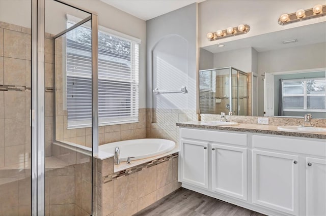 bathroom with hardwood / wood-style floors, vanity, and independent shower and bath