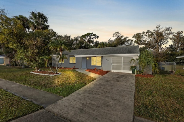 ranch-style house featuring a lawn and a garage