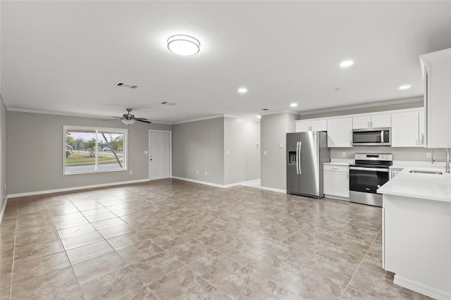 kitchen with ornamental molding, stainless steel appliances, ceiling fan, sink, and white cabinetry