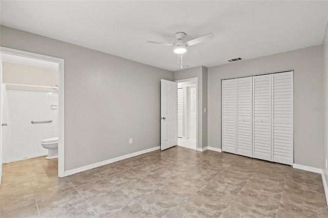 unfurnished bedroom with a closet, ensuite bathroom, and ceiling fan