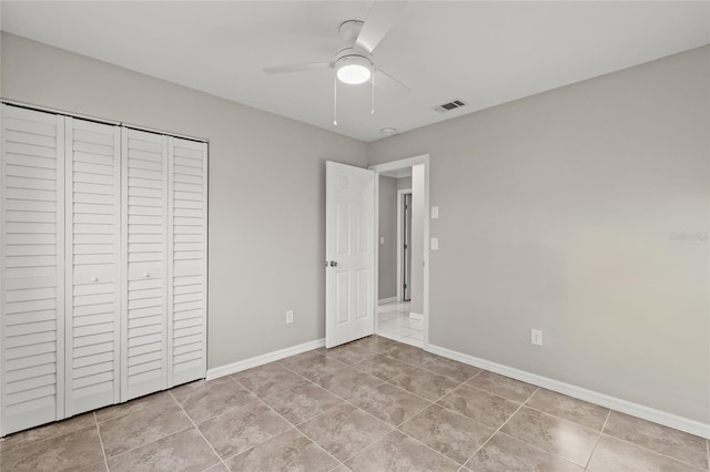 unfurnished bedroom featuring ceiling fan, a closet, and light tile patterned flooring