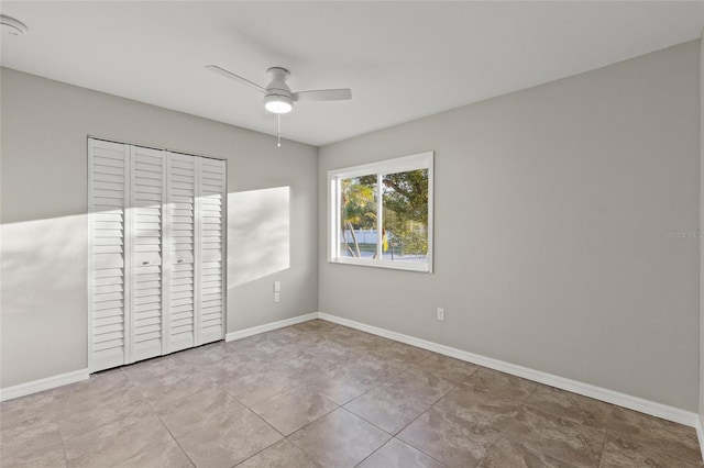 unfurnished bedroom featuring ceiling fan and a closet